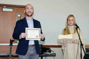 Cody Copeland is awarded First Place in his Poster Group at the Social Science Student Symposium (November 10, 2018) by Assistant Dean of the School of Sciences, Dr. Billi Patzius.